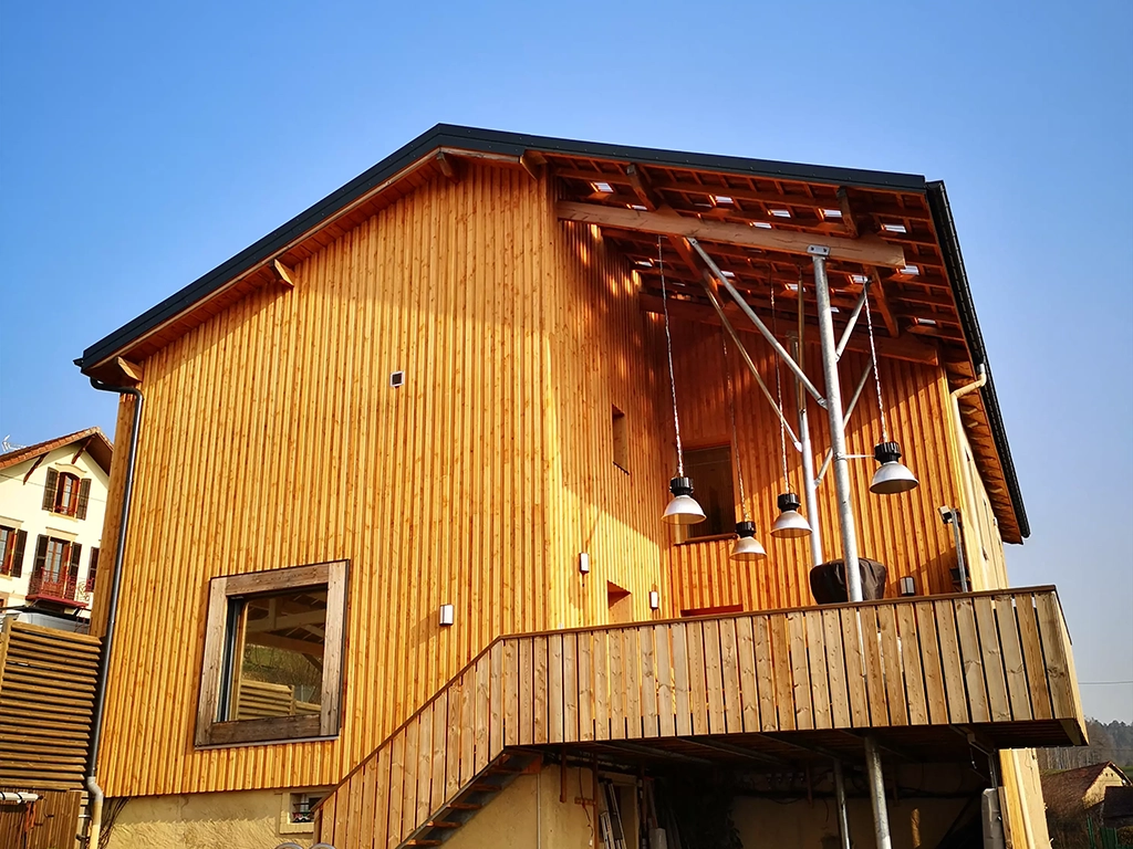 Façade de maison entièrement en bardage bois clair